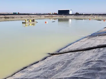 Lined wastewater lagoon with a hydraulic dredge at work