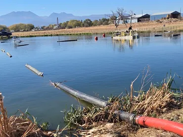 Floating discharge pipeline and dredge on a settling pond
